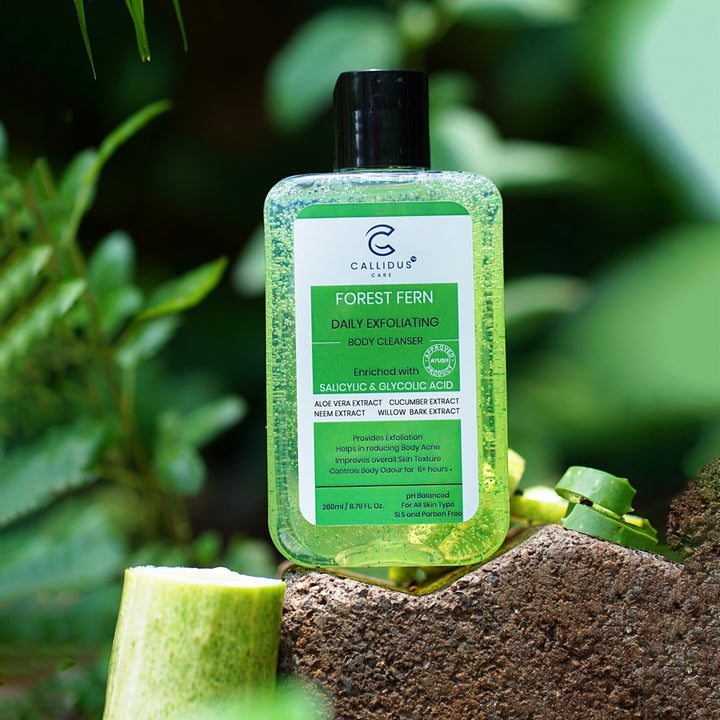 Callidus Care Forest Fern Body Cleanser bottle displayed outdoors on a stone with green foliage in the background.