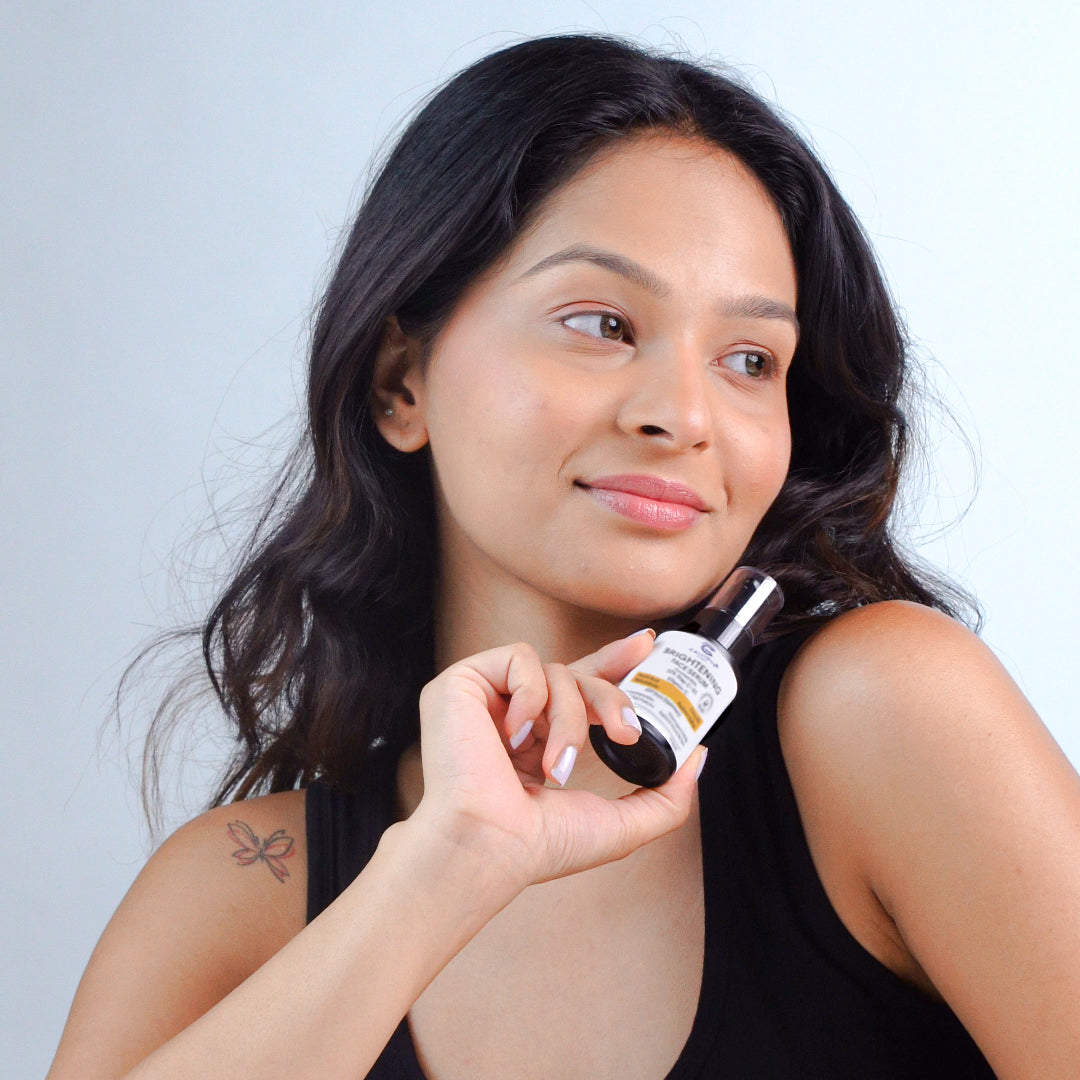 Woman holding a bottle of skincare product against a light background