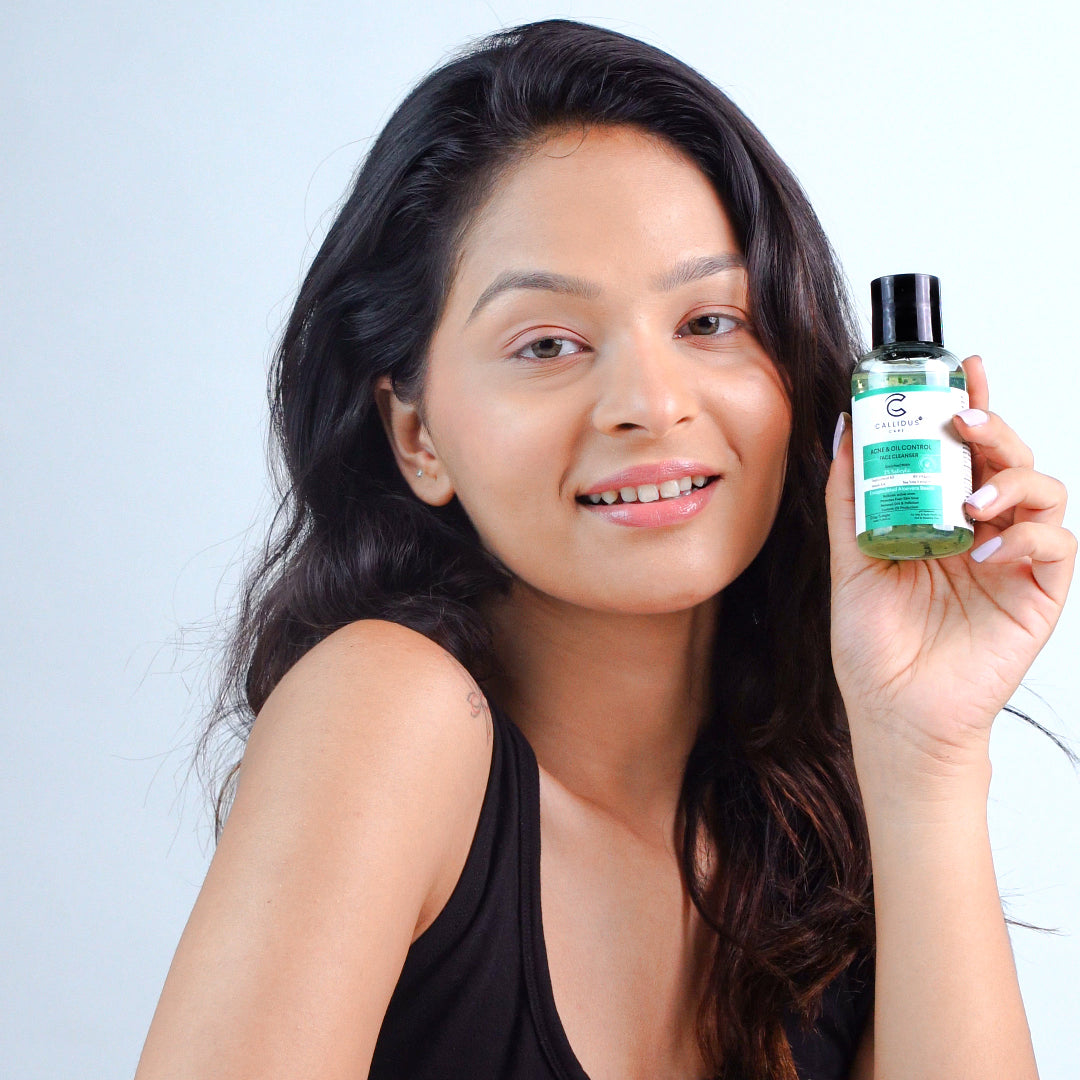 Woman holding a bottle of skincare product against a light background