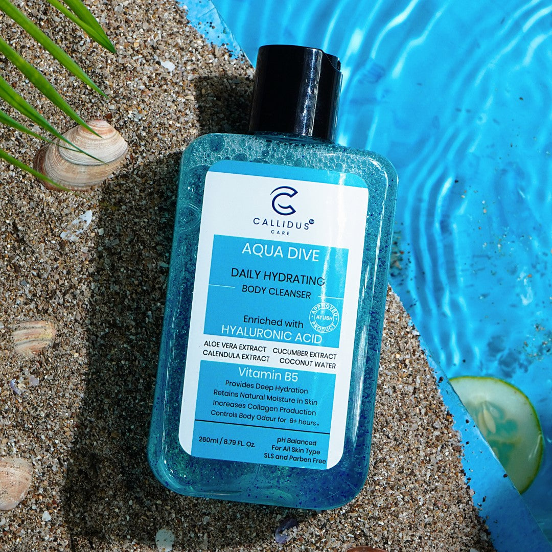 Callidus Care Aqua Dive Body Cleanser bottle on sand by poolside with seashells.